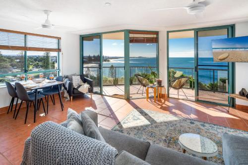 a living room with a couch and a table at Ocean Front Views with Rooftop Terrace in Caloundra