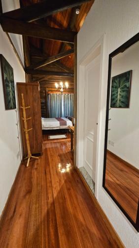 a hallway with a room with a bed and a mirror at Aldeia Flor de Liz - Pedra Azul in Pedra Azul