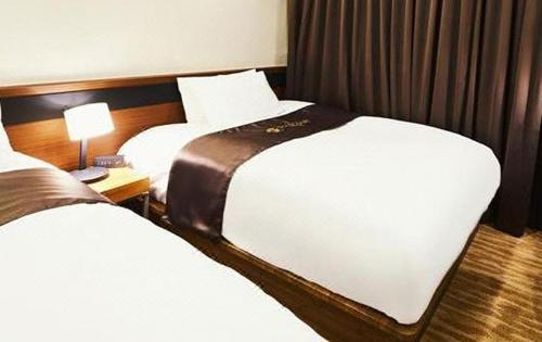 a hotel room with two beds and a lamp at Gold Coast Hotel Incheon in Incheon