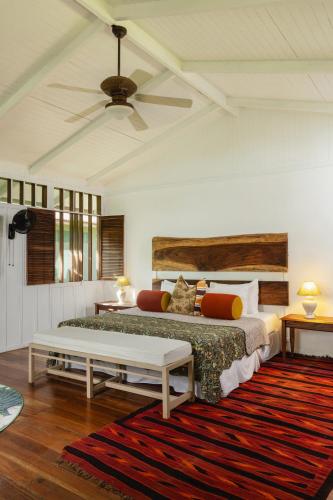 a bedroom with a bed and a couch and a table at Mawamba Lodge in Tortuguero