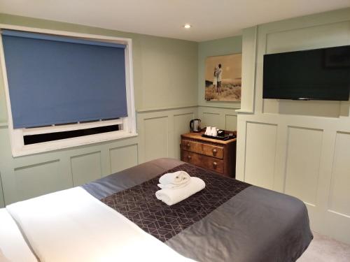 a bedroom with a bed with a white towel on it at The Willows in Brighton & Hove