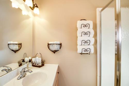 a bathroom with a sink and towels on the wall at Lakefront Isle Escape with Dock and Fire Pit! in Isle