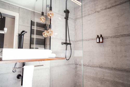 a bathroom with a shower with a sink and a mirror at Hotel City Maribor in Maribor
