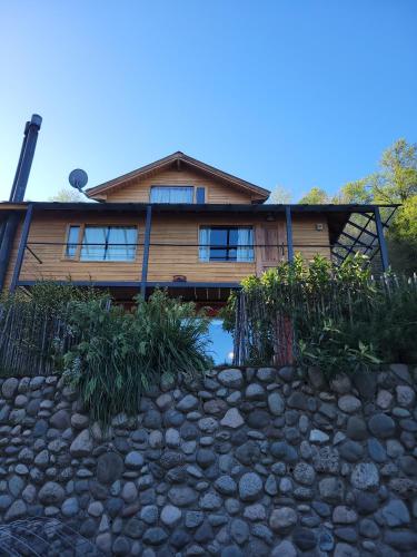 a log house with a stone path in front of it at Hogar de Montaña in San Martín de los Andes
