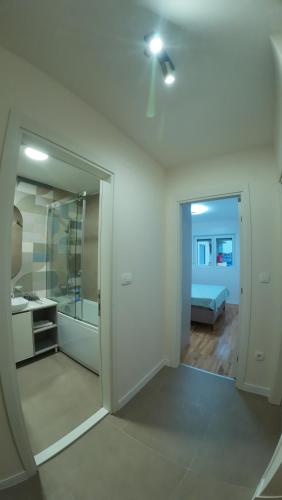 a white room with a bathroom and a bedroom at Apartments Eagle, close to center Podgorica, free parking, available transport in Podgorica