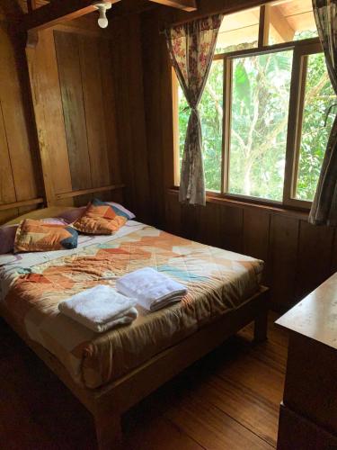 a bedroom with a bed with two towels on it at El Descanso in Mindo