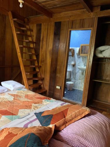a bedroom with a ladder and a bed and a mirror at El Descanso in Mindo