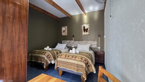 two beds sitting next to each other in a room at Hostal Pablito in San Pedro de Atacama