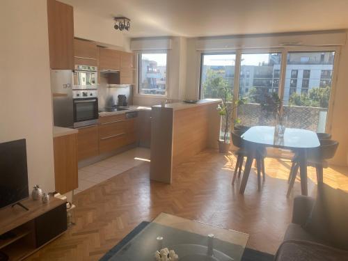 Il comprend une cuisine et un salon avec une table. dans l'établissement Stylish cosy appt, à Asnières-sur-Seine