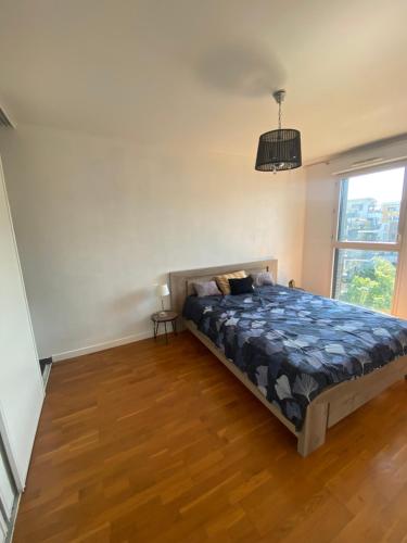 une chambre avec un lit et une grande fenêtre dans l'établissement Stylish cosy appt, à Asnières-sur-Seine