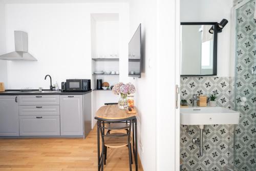 une cuisine avec une table avec un vase de fleurs dessus dans l'établissement Wally Apartments by Flat White - With Elevator, à Zagreb