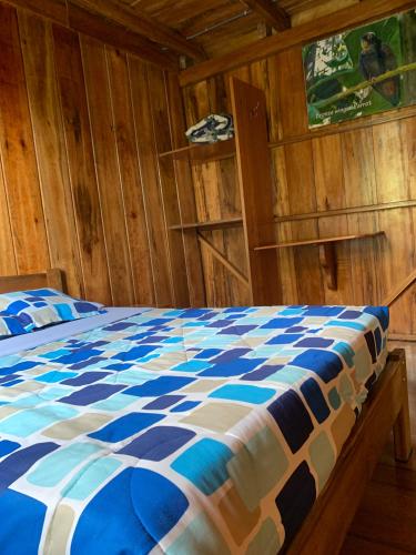 a bedroom with a blue and white comforter on a bed at El Descanso in Mindo