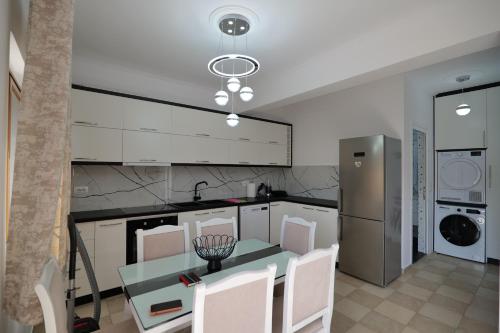 a kitchen with a table and chairs in a kitchen at Loris Apartment in Sarandë