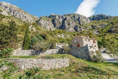an old building on a hill with mountains in the background at Villa Sveti Stefan in Budva