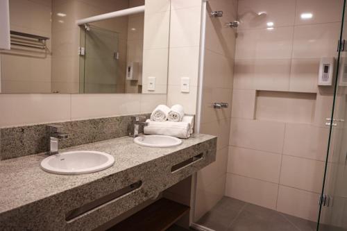 a bathroom with two sinks and a shower at Aconchegante Flat em Canela - RS - Serra Class in Canela