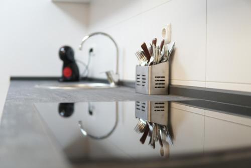 a kitchen counter with a sink and a counter top with utensils at Casa Fausto Lasarte-oria in Lasarte