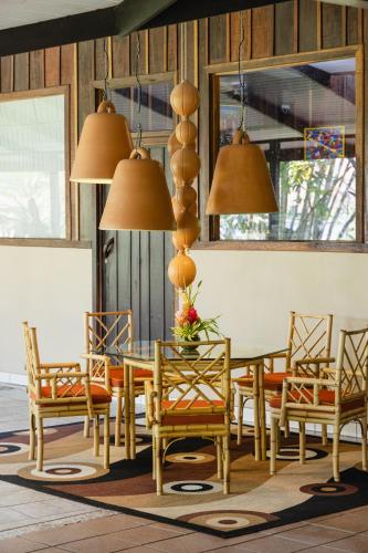 a dining room with a table and chairs and lights at Mawamba Lodge in Tortuguero