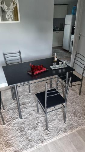 - une table et des chaises noires dans le salon dans l'établissement Bien etre, à Drancy