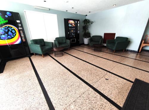 a waiting room with chairs and a video game at Hotel Habana in Mexico City