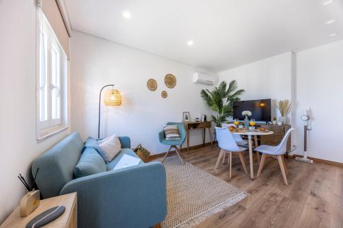 a living room with a blue couch and a table at Casa Clara in Vila do Bispo
