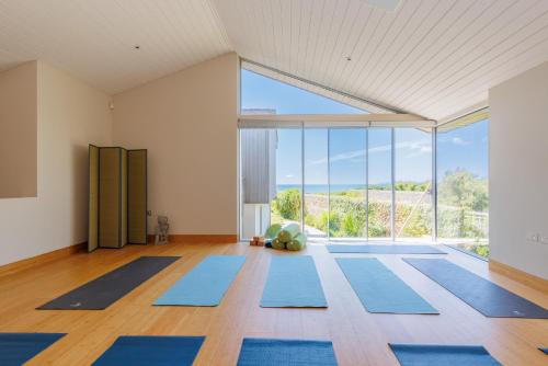 a room with blue mats in front of a large window at Vegan Seafront Retreat & Yoga Studio in West Wittering in West Wittering