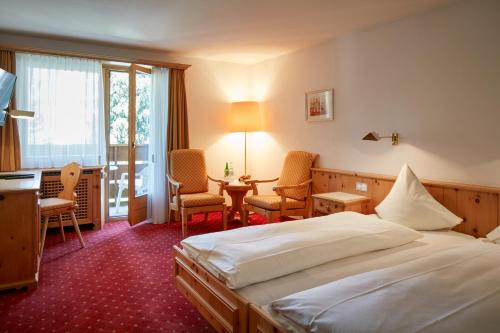 Postel nebo postele na pokoji v ubytování Hotel Steinbock Pontresina