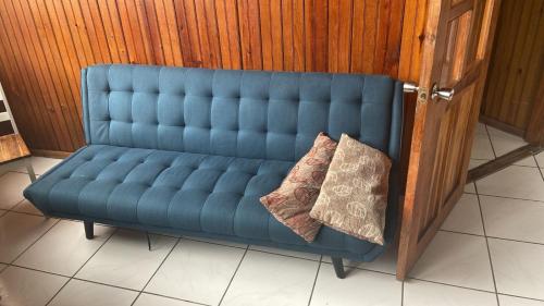 a blue couch with two pillows sitting on it at Coconut Tree West Bay in West Bay