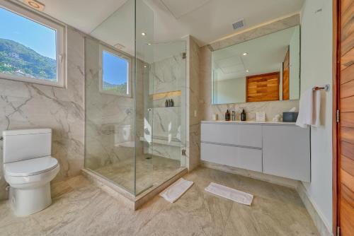 a bathroom with a shower and a toilet and a sink at Maxwell Residences at Indah in Puerto Vallarta