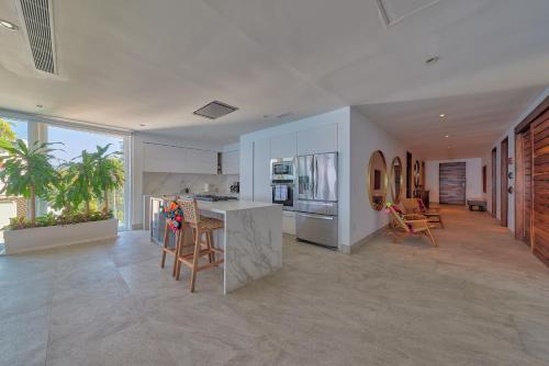 a kitchen and living room with a table and chairs at Maxwell Residences at Indah in Puerto Vallarta