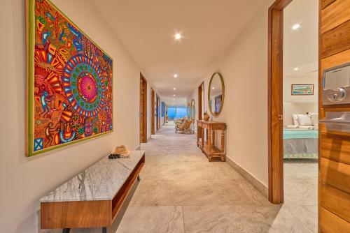 a hallway with a large colorful painting on the wall at Maxwell Residences at Indah in Puerto Vallarta