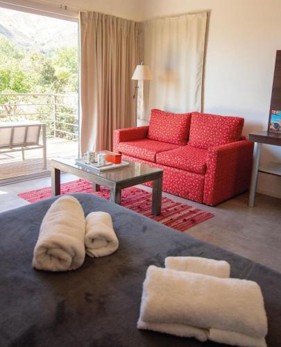 a living room with a red couch and two towels at Rumbo 020 Apart in Merlo