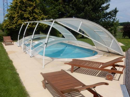 une piscine avec un couvercle et deux bancs dans l'établissement Chalet cosy avec piscine privée au Val-d'Ajol, 3 chambres - FR-1-589-597, à Le Val-dʼAjol