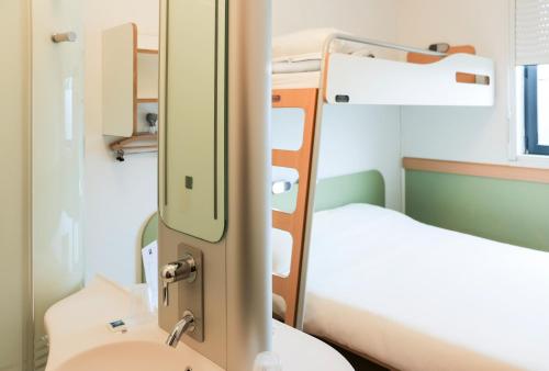 a hospital room with two beds and a sink at ibis budget Castelnaudary - A61 in Castelnaudary