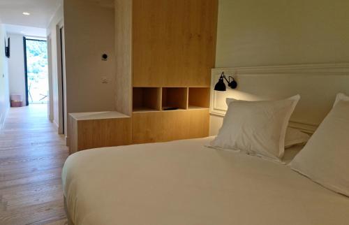 a bedroom with a large white bed and wooden floors at Beau Rivage in Charavines