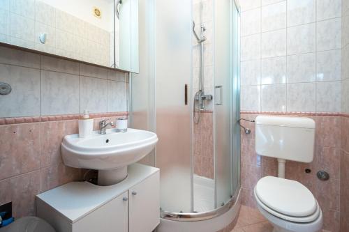 ein Badezimmer mit Waschbecken, Toilette und Dusche in der Unterkunft Apartments by the sea Stara Novalja, Pag - 21662 in Stara Novalja