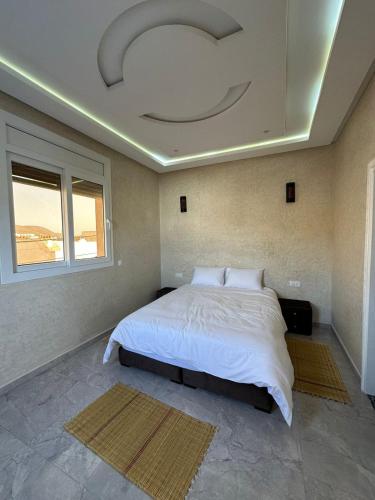 a bedroom with a large bed with a ceiling at Villa sérénité in Mirleft