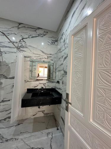 a bathroom with a sink and a mirror and a door at Villa sérénité in Mirleft