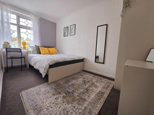 a bedroom with a bed with a mirror and a rug at Beautiful rooms in PRIME location! in London