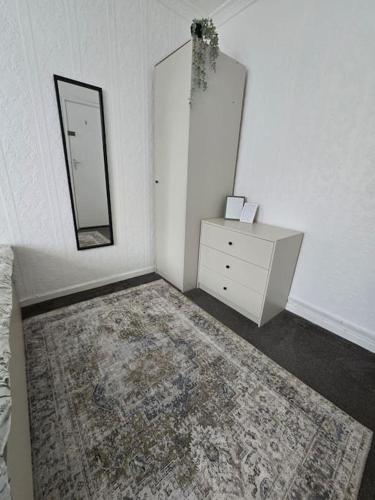 a room with a dresser and a mirror and a rug at Beautiful rooms in PRIME location! in London