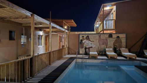 a house with a swimming pool at night at Hostal Pablito in San Pedro de Atacama