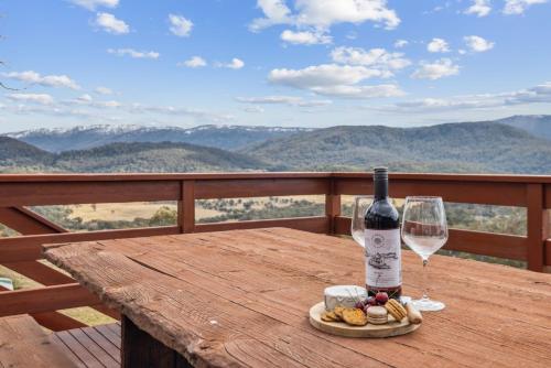 a bottle of wine and a glass on a wooden table at Nowhere Lodge in Crackenback