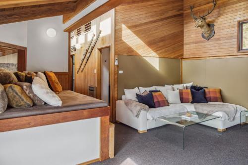 a living room with a couch and a table at Nowhere Lodge in Crackenback