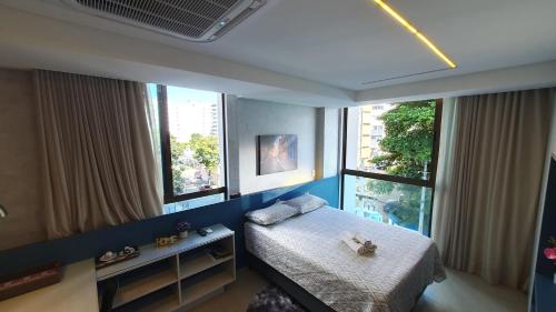 a small bedroom with a bed and two windows at Flat em Boa Viagem - Edifício Rooftop 470 in Recife