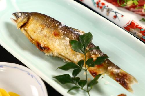 a white plate with a piece of fish on it at 富士見山荘 in Izu