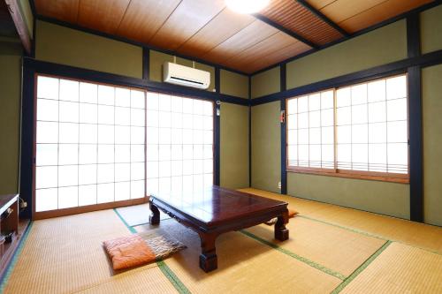 a room with a table and two large windows at 富士見山荘 in Izu