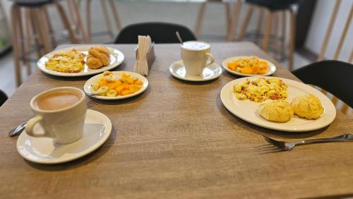 a table with plates of food and cups of coffee at Waldor's Hotel Boutique in Leticia