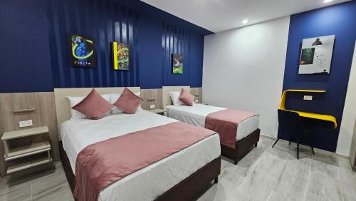 a hotel room with two beds and blue walls at Waldor's Hotel Boutique in Leticia