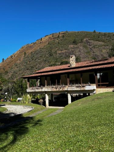 a large building with a mountain in the background at Recanto dos Vianas in Teresópolis