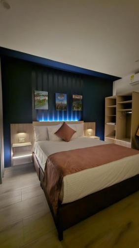 a bedroom with a large bed with a blue wall at Waldor's Hotel Boutique in Leticia