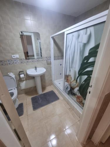 a bathroom with a shower and a toilet and a sink at Appartement MARINA AP4 SAIDIA in Saïdia